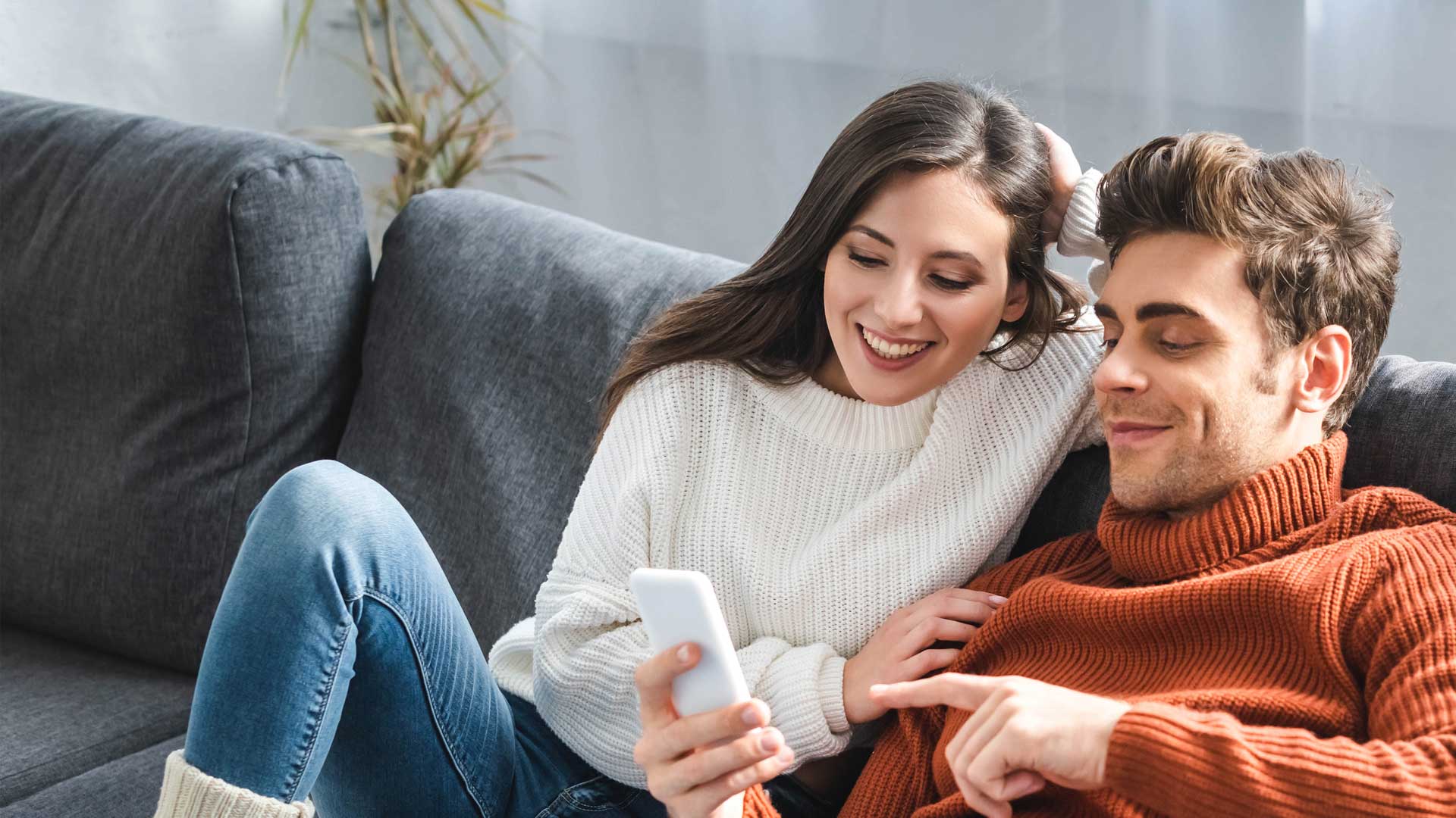 couple-on-couch-smiling-at-phone-2